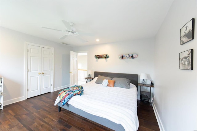 bedroom with dark wood-type flooring, ceiling fan, and a closet