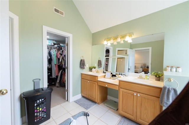 bathroom featuring lofted ceiling, tile patterned flooring, and vanity