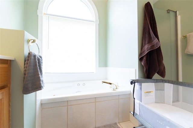 bathroom with a wealth of natural light and a relaxing tiled tub