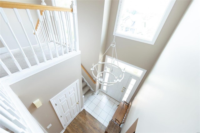 tiled foyer entrance with a wealth of natural light and a notable chandelier