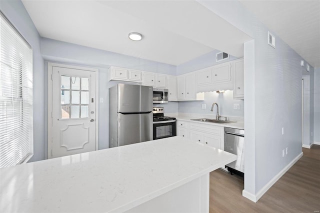 kitchen featuring light hardwood / wood-style flooring, white cabinets, light stone countertops, appliances with stainless steel finishes, and sink