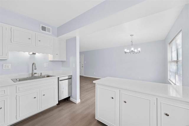 kitchen featuring white cabinets, sink, a chandelier, dishwasher, and wood-type flooring