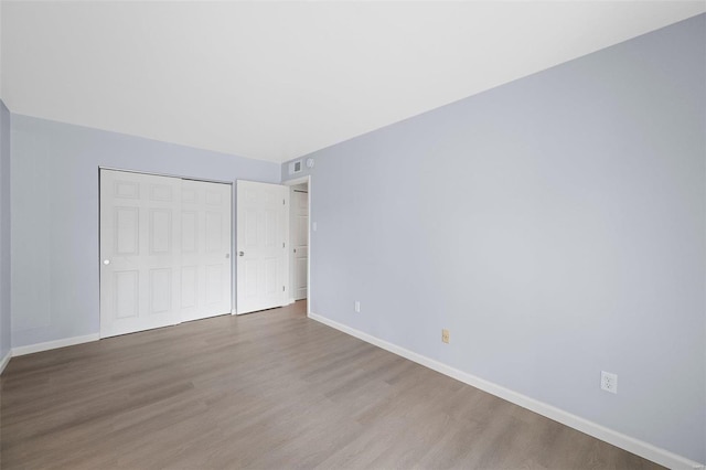 unfurnished bedroom with a closet and hardwood / wood-style flooring