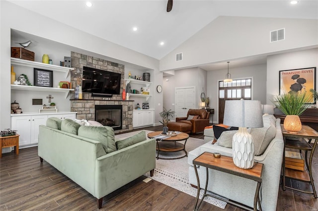 living room with dark hardwood / wood-style floors, a stone fireplace, and high vaulted ceiling