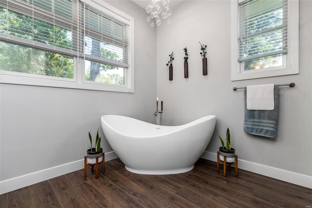 bathroom with hardwood / wood-style floors and an inviting chandelier