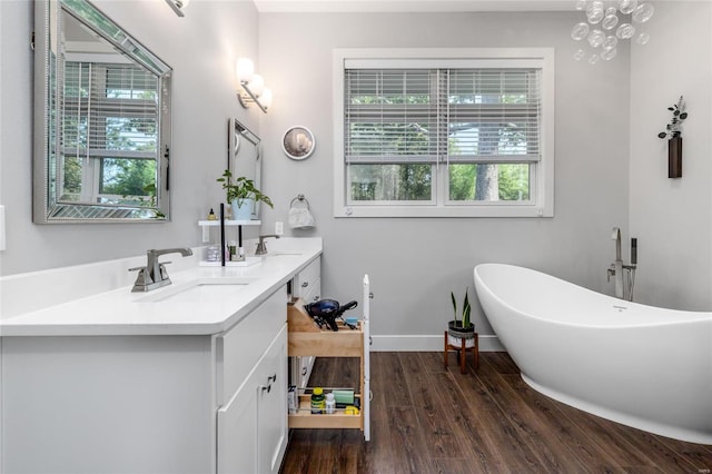 bathroom featuring double vanity, a bathtub, and hardwood / wood-style flooring