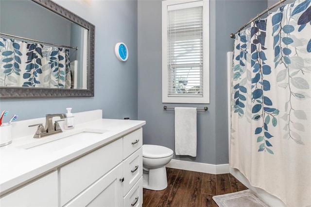 bathroom with wood-type flooring, vanity, and toilet