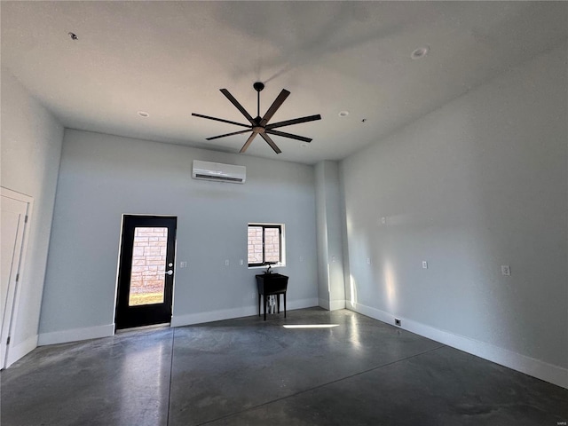 spare room featuring an AC wall unit, ceiling fan, and a towering ceiling