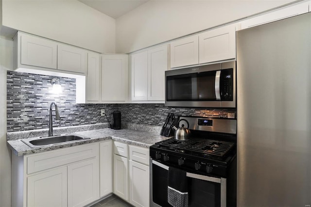 kitchen featuring appliances with stainless steel finishes, white cabinetry, and sink