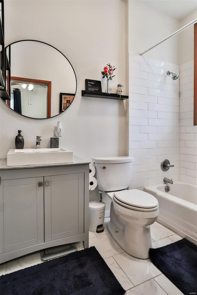 full bathroom featuring toilet, tiled shower / bath combo, and vanity