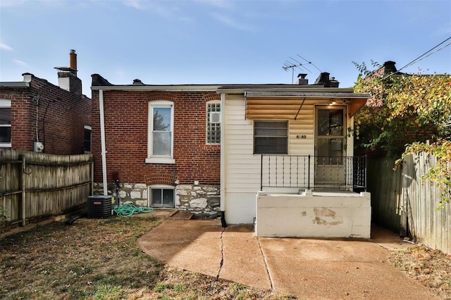 back of property with a patio and central AC