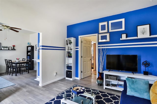 living room featuring wood-type flooring and ceiling fan