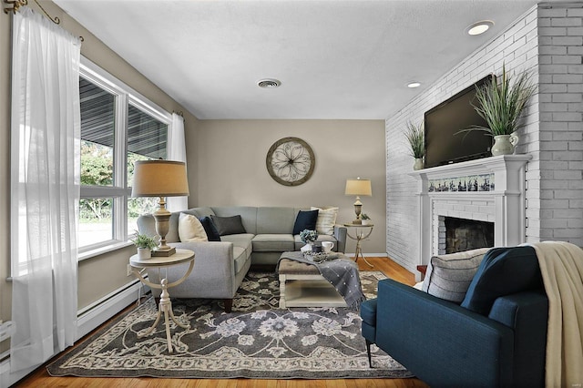 living room with a fireplace, wood-type flooring, and a textured ceiling