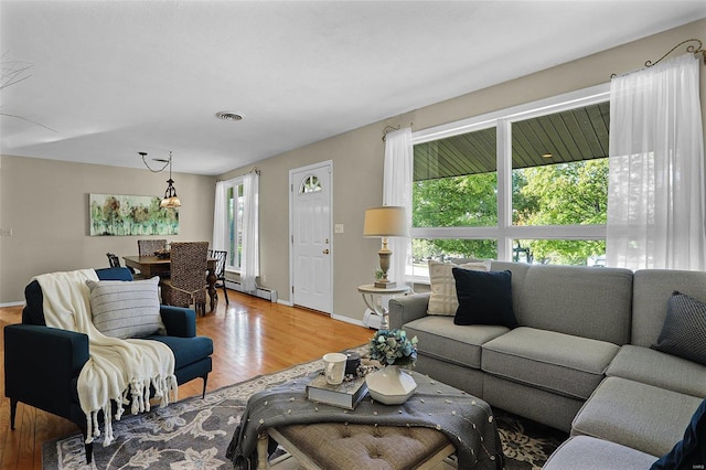 living room with hardwood / wood-style floors and a baseboard heating unit