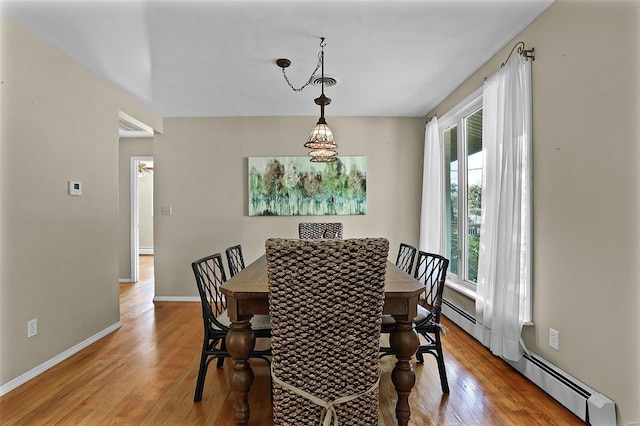 dining area with hardwood / wood-style floors and a baseboard heating unit