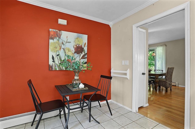 dining area with light hardwood / wood-style floors, crown molding, and baseboard heating