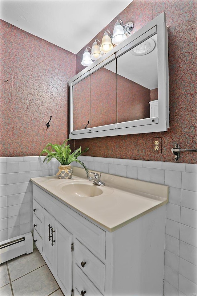 bathroom with a baseboard radiator, tile patterned flooring, tile walls, and vanity