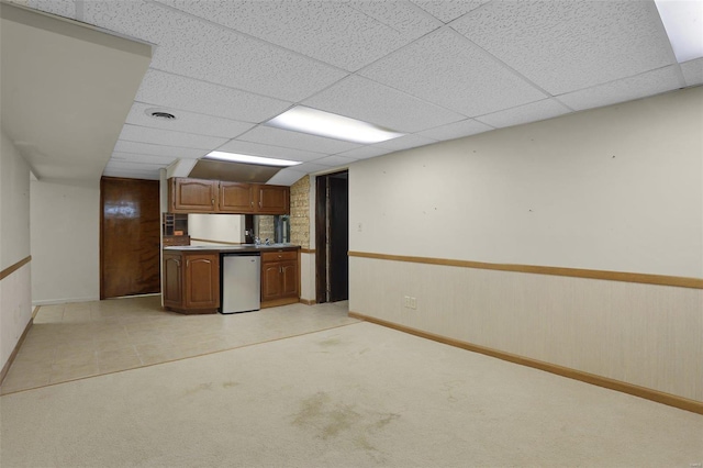 kitchen featuring white fridge, a paneled ceiling, light carpet, and dishwasher