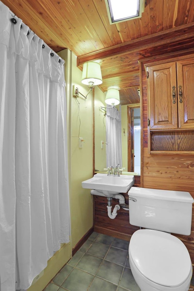 bathroom with tile patterned flooring, wood walls, toilet, and wooden ceiling