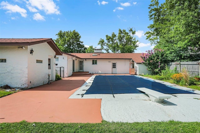 view of pool with a diving board and a patio area