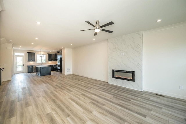 unfurnished living room with a fireplace, hardwood / wood-style flooring, and ceiling fan