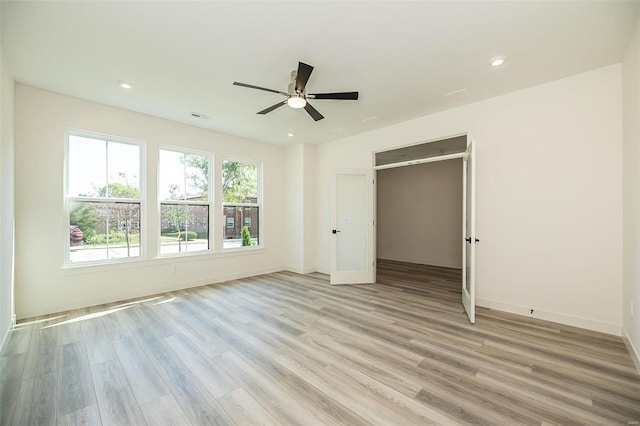 unfurnished bedroom with ceiling fan and light hardwood / wood-style flooring