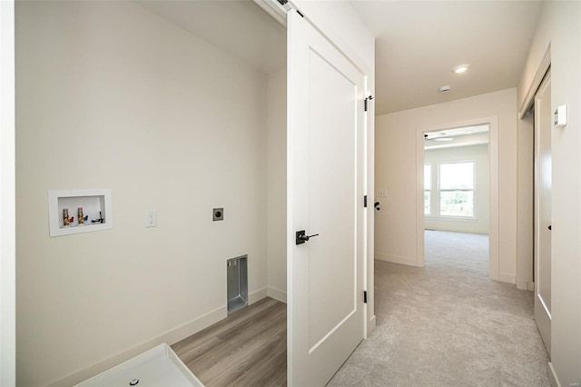 clothes washing area with washer hookup, light colored carpet, electric dryer hookup, and a barn door