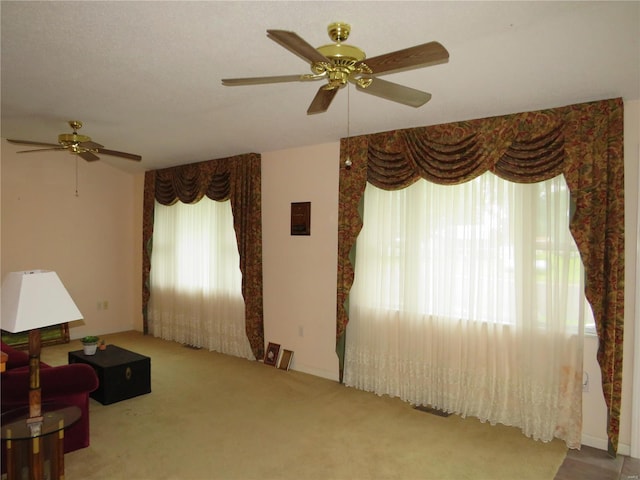 carpeted living room with ceiling fan