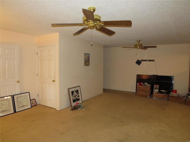 misc room featuring a textured ceiling, light colored carpet, and ceiling fan