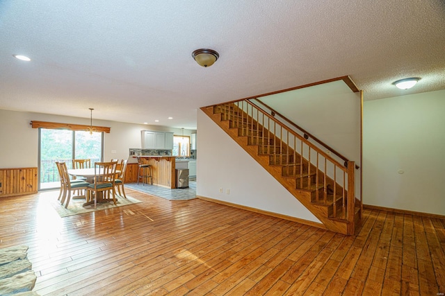 dining room with baseboards, stairs, a textured ceiling, light wood-type flooring, and recessed lighting