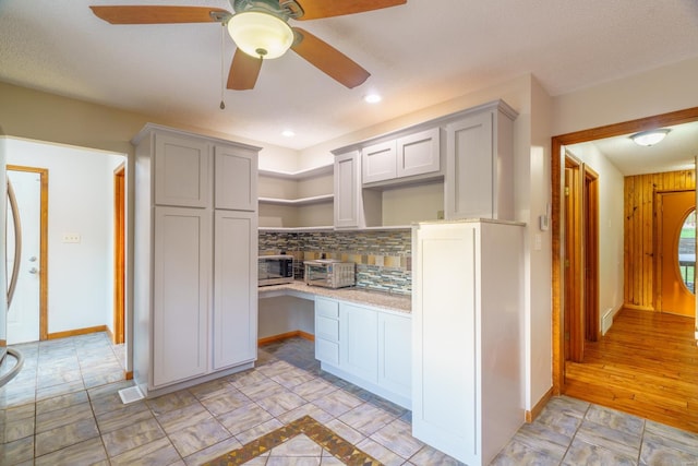 kitchen featuring gray cabinetry, baseboards, decorative backsplash, and open shelves