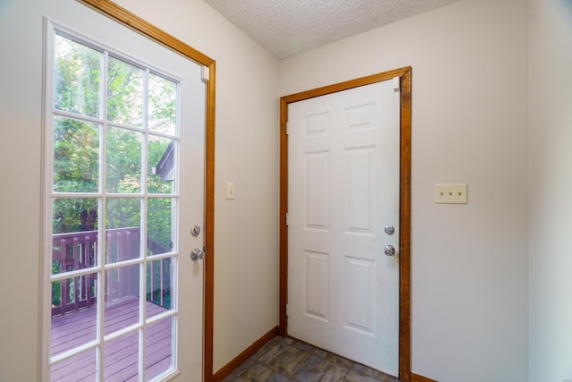 entryway featuring baseboards and a textured ceiling