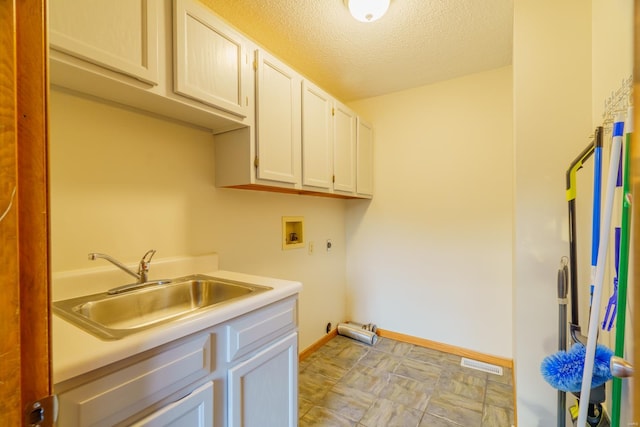 clothes washing area with cabinet space, visible vents, a textured ceiling, washer hookup, and a sink