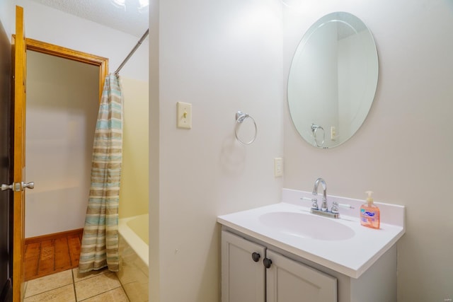 bathroom with shower / bathtub combination with curtain, vanity, and tile patterned floors