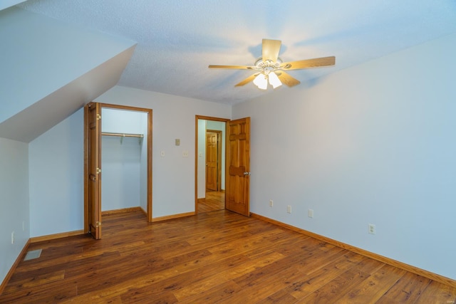 unfurnished bedroom featuring hardwood / wood-style flooring, a ceiling fan, baseboards, and a closet