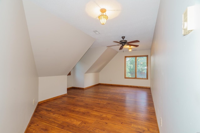 bonus room with vaulted ceiling, a ceiling fan, hardwood / wood-style flooring, and baseboards