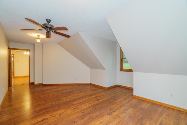 additional living space featuring a ceiling fan, lofted ceiling, baseboards, and hardwood / wood-style floors