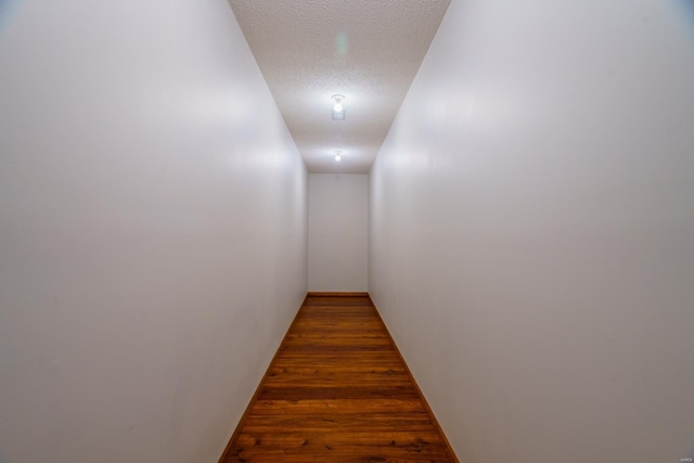 hall featuring a textured ceiling and wood finished floors