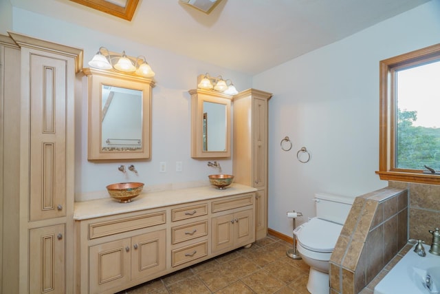 full bathroom featuring a tub to relax in, toilet, baseboards, tile patterned floors, and double vanity