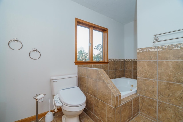 bathroom with baseboards, toilet, and a whirlpool tub