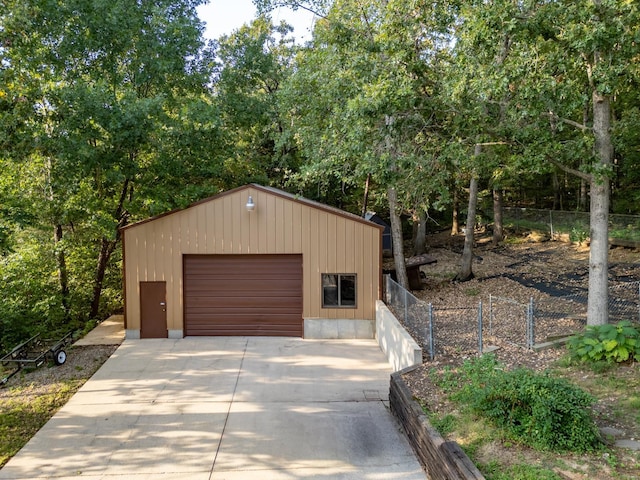 detached garage with fence and concrete driveway