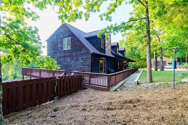 view of home's exterior featuring fence and a wooden deck