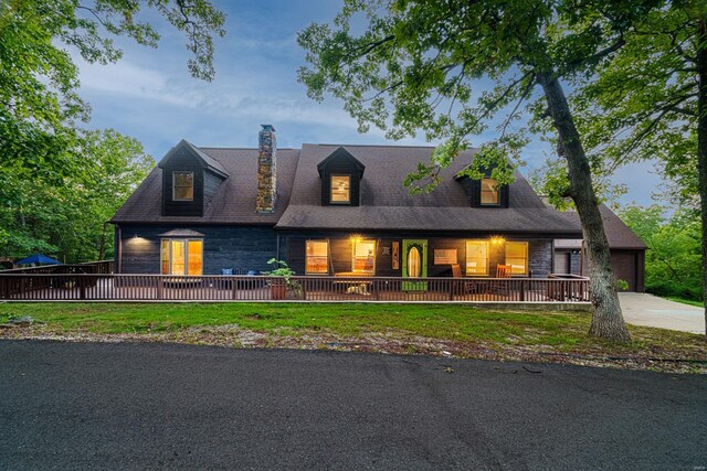 view of front of home featuring covered porch, a chimney, and stone siding