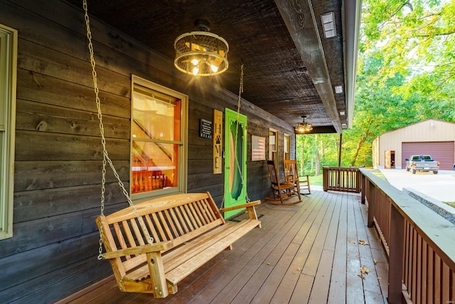 wooden deck featuring a porch and an outbuilding