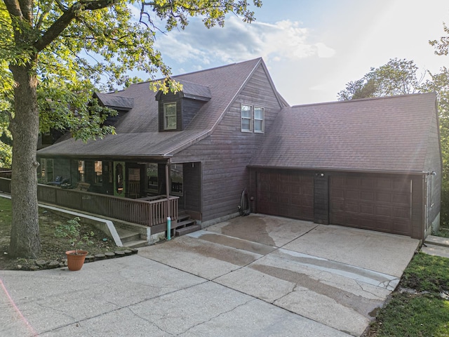 view of front of property with an attached garage, a shingled roof, a porch, and concrete driveway