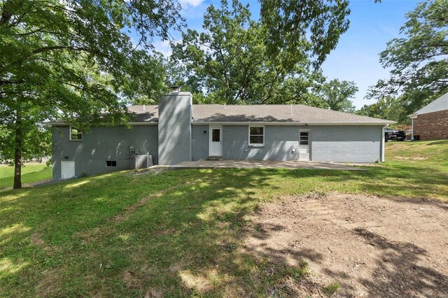 back of property with a yard and a patio