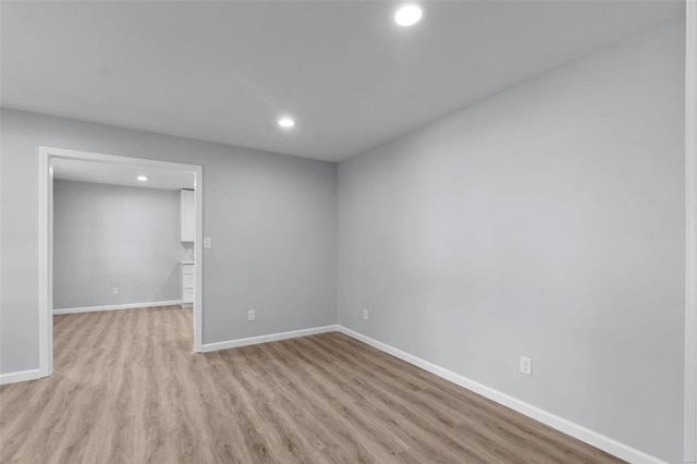 spare room featuring light wood-style floors, recessed lighting, and baseboards