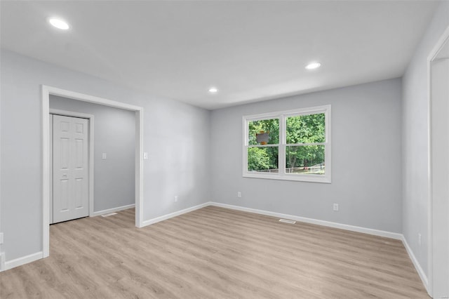 unfurnished room with baseboards, light wood finished floors, and recessed lighting