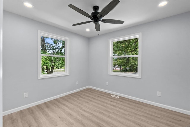 spare room with light wood-type flooring, plenty of natural light, baseboards, and recessed lighting