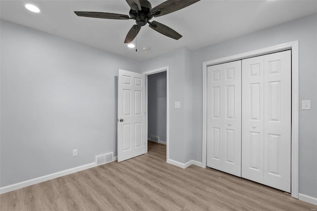 unfurnished bedroom with a closet, light wood-type flooring, visible vents, and baseboards